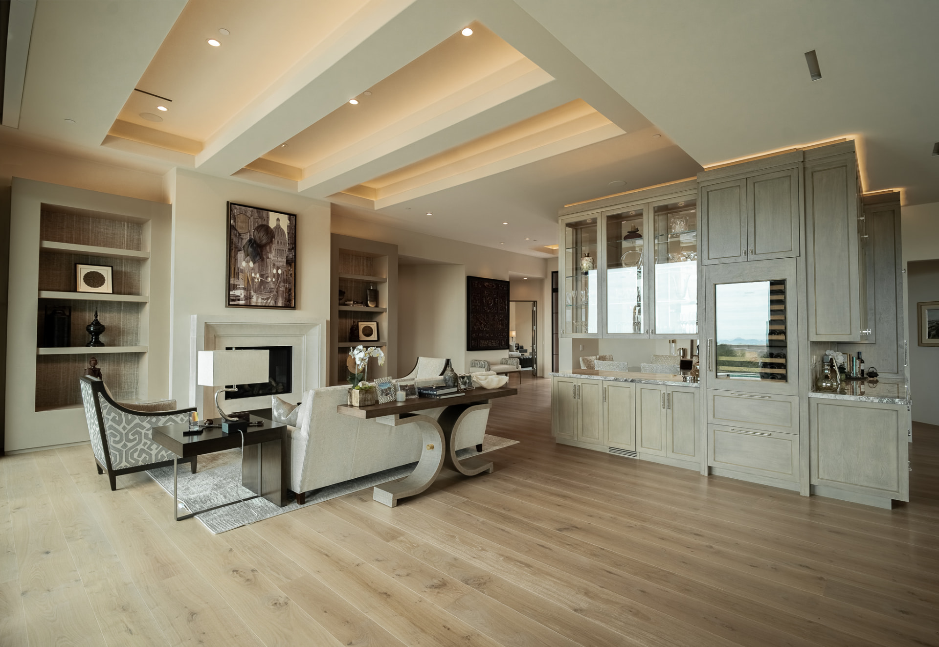 Formal living room with a beamed ceiling and fireplace, beside a wet bar with glass-front cabinets and a wine refrigerator
