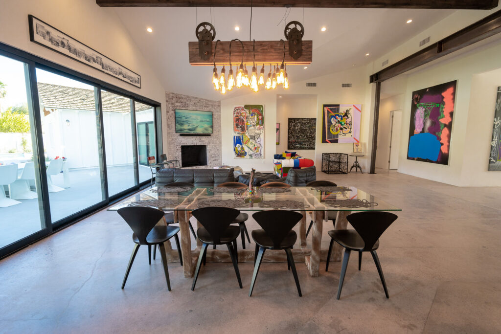 Dining room with a glass table, suspended lighting and sliding patio doors