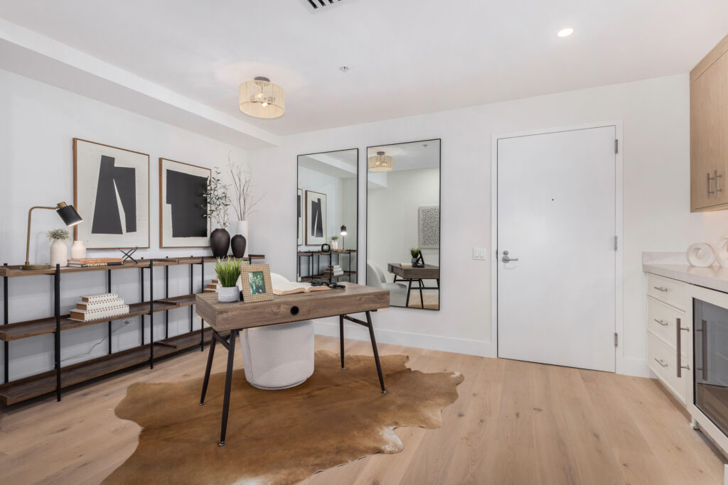 Flex room with a writing desk, mirrors, a cowhide rug and a wet bar