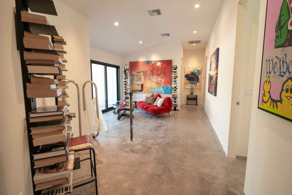 Entry gallery with contemporary artwork and a red lounge chair