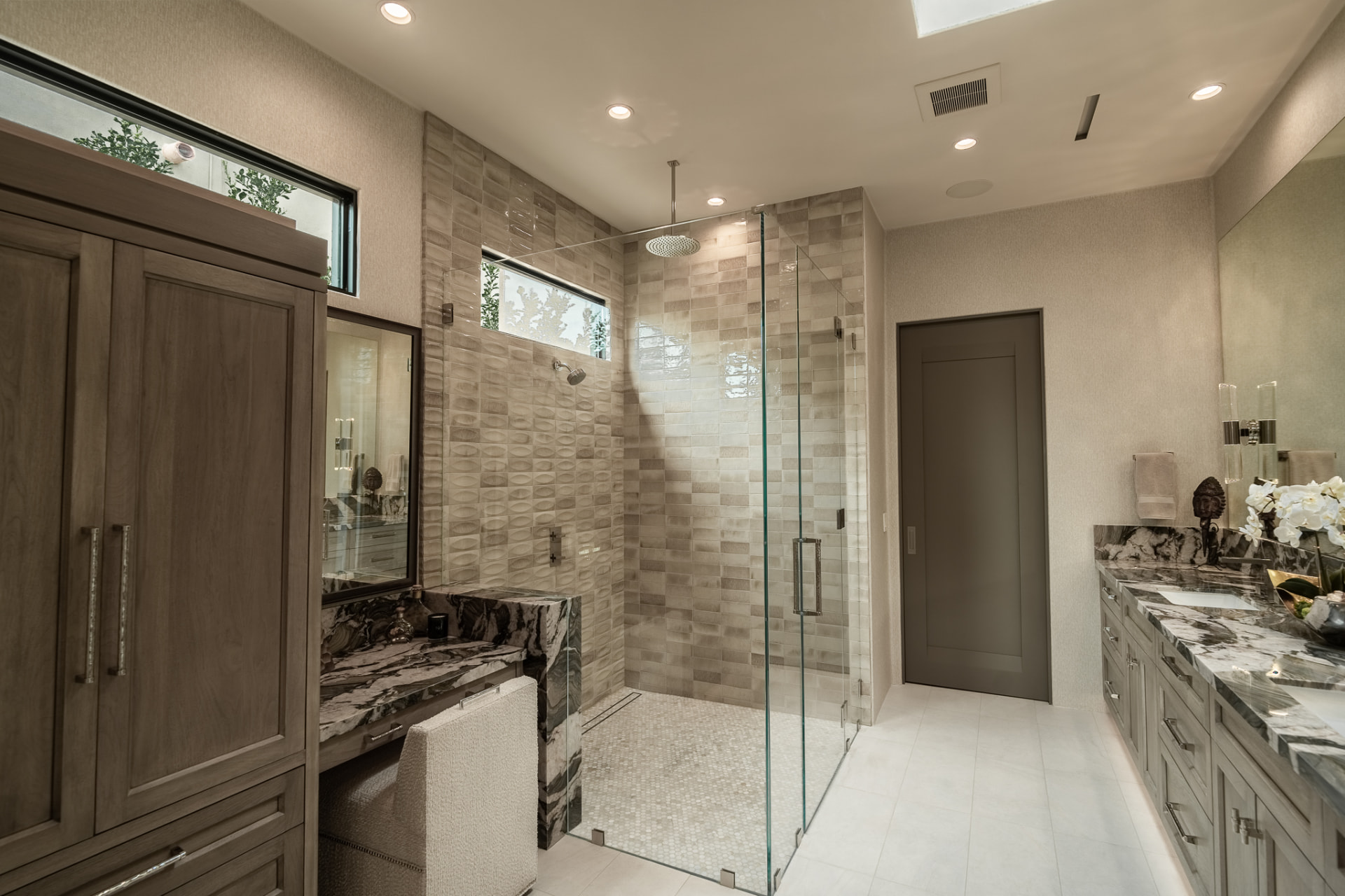 Bathroom with a walk-in glass shower, vanity and a makeup seating area